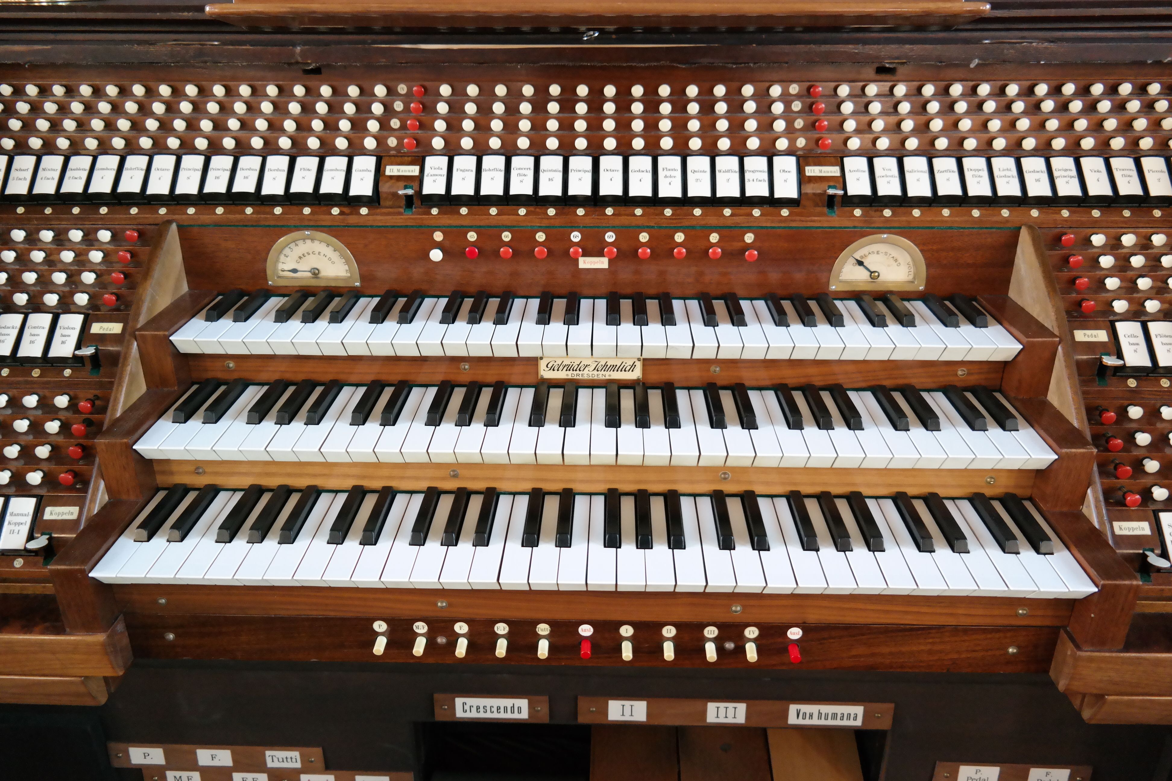 weiße Orgel-Klaviatur mit Tasten, Registern und drei Manualen