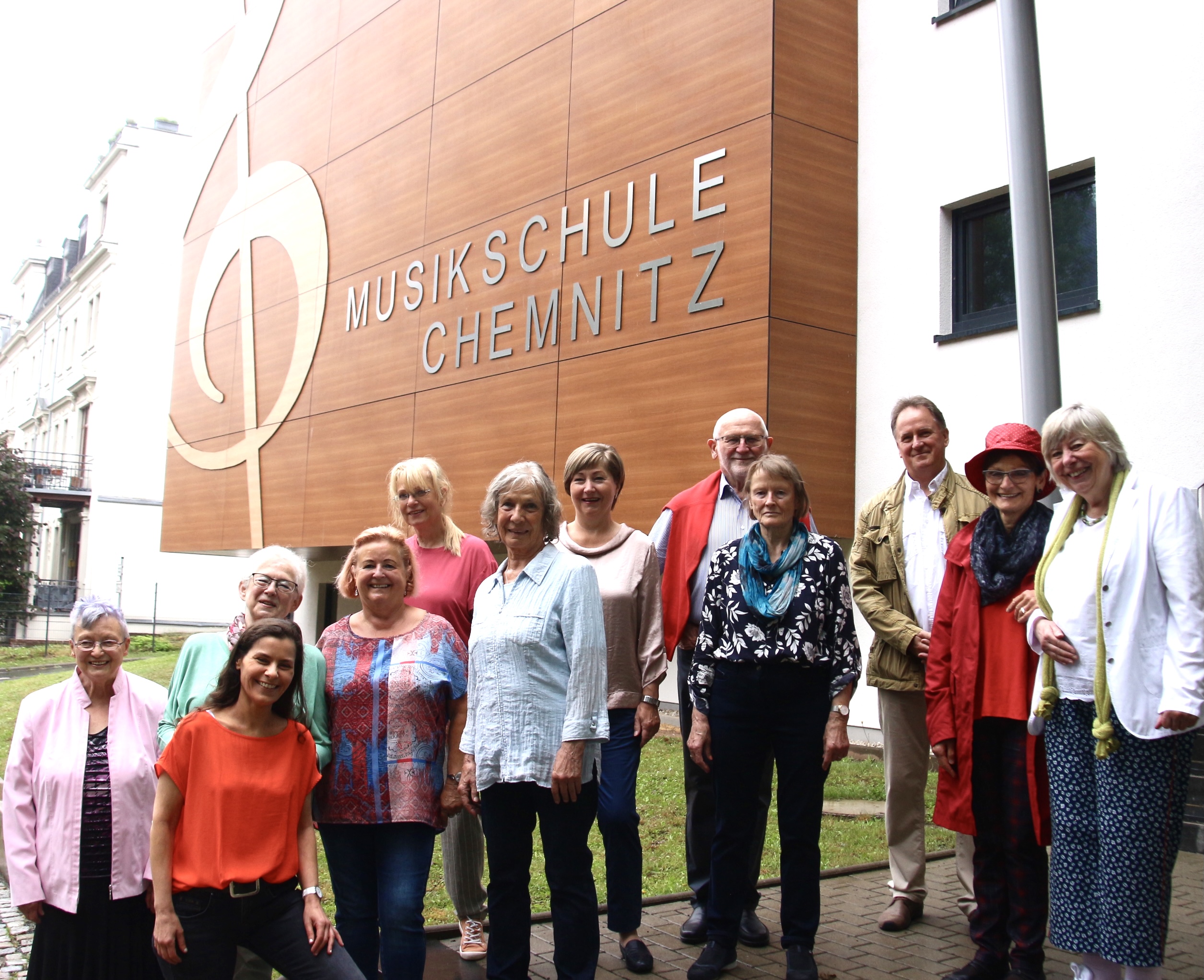 Gruppenfoto des Ensembles SING MIT! vor dem Anbau der Musikschule 