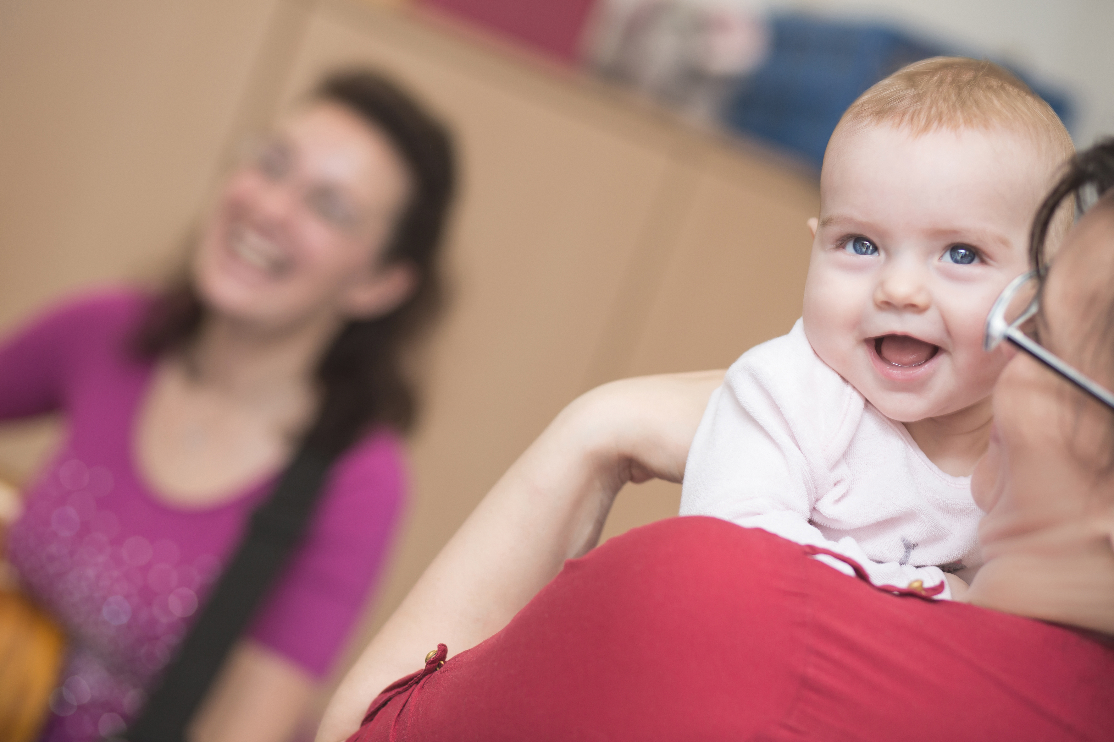 Kleines lachendes Baby auf der Schulter der Großmutter.