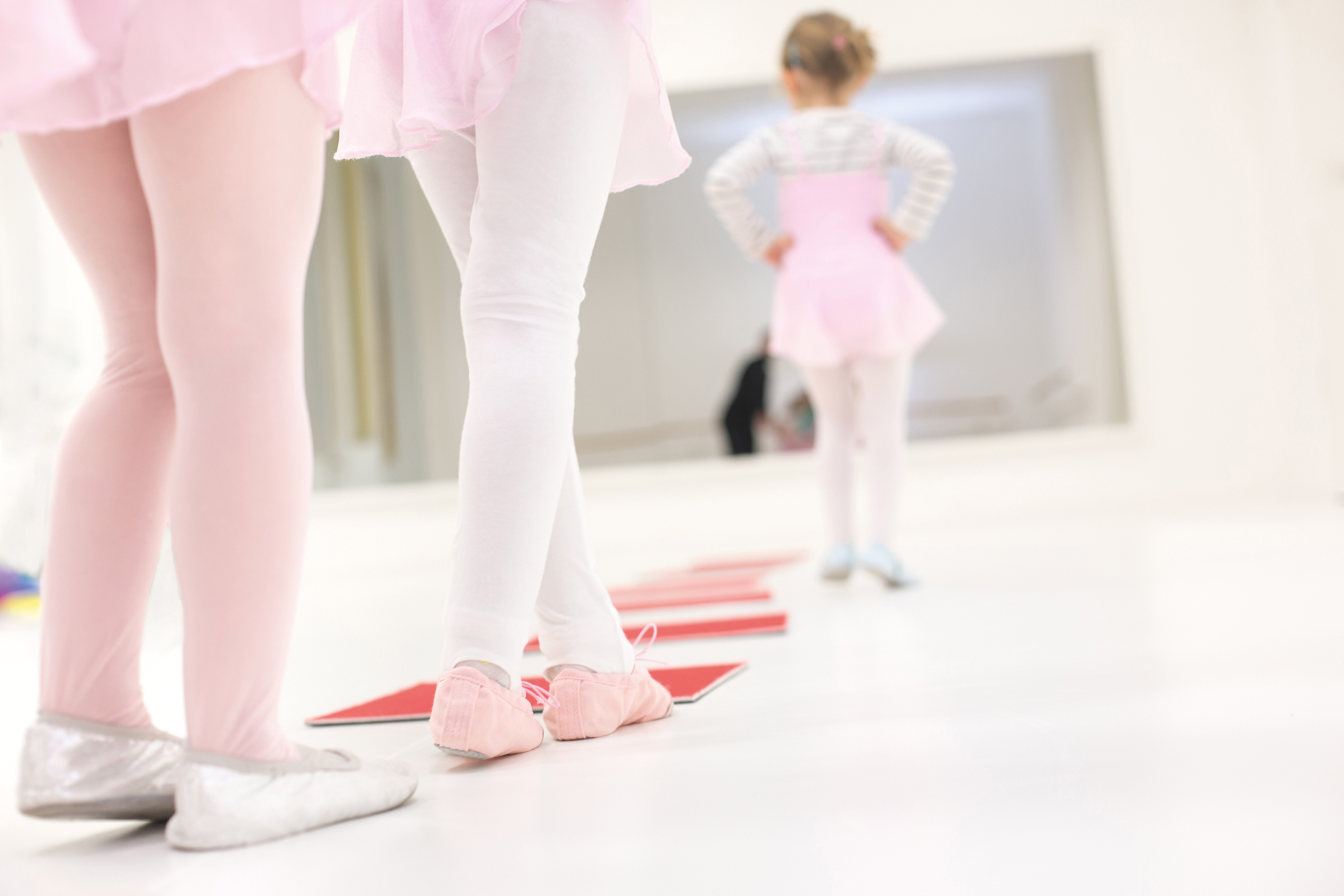 kleine Ballett-Tänzerinnen schreiten den Raum entlang