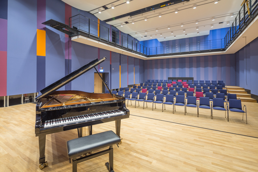 Blick von einer Bühne mit Flügel in den Konzertsaal der Musikschule