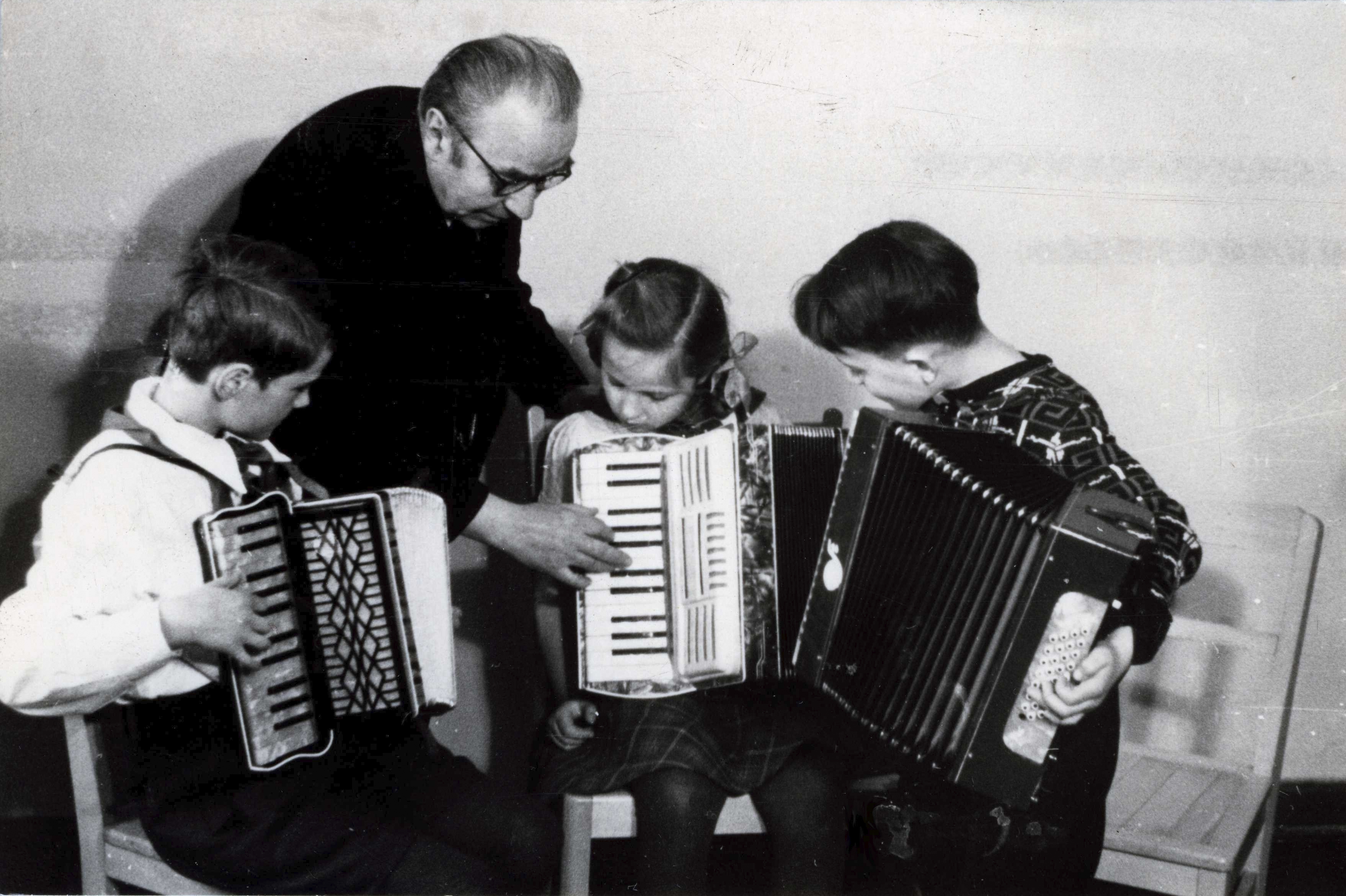 altes Bild von Bandoneon-Lehrer der drei Kinder unterrichtet, aus der Zeit als die Musikschule noch Volksmusikschule hieß